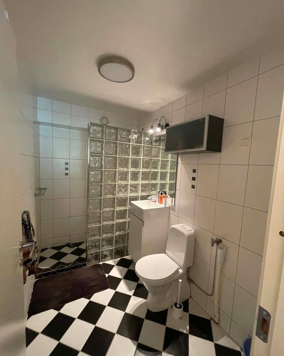 Bad i Bergfrueveien på Rolvsøy før renovering, med glassbyggestein og sjakkrutet gulv
