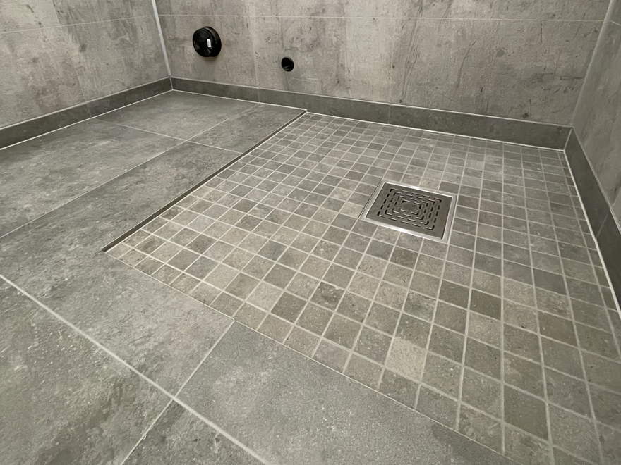 Dusjsone i mosaikk med fall mot sluk, betonglook storformat på resten av gulvet